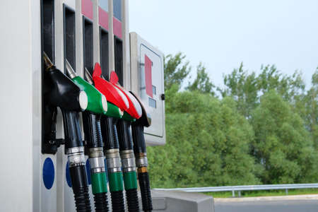 Gasoline and oil products concept. Red and black fuel pistols on fuel station.To fill car with...