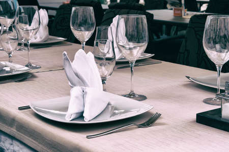 Wineglasses served for a festive dinner. Table setting in restaurant. Decorated holiday table.の写真素材