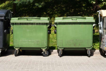 Dustbins being full with garbage. Garbage bins in city community. Green garbage bins in town.の写真素材