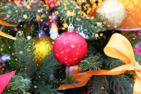 Christmas red ball with a garland hanging on pine branches with festive background. Merry Christmas and Happy New Year.の写真素材