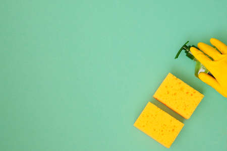 Top view. Hand in yellow rubber protective glove whith sponges. Housework and housekeeping concept.の写真素材