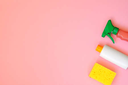 Cleaning products on pink background. Detergents and sponge. Housework and household concept. Top view. Copy space.の写真素材