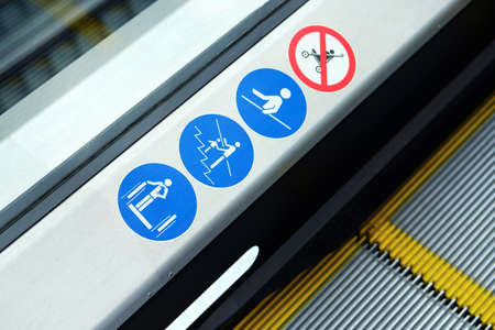 Escalator and modern shopping mall interior. Information signs on the steps.