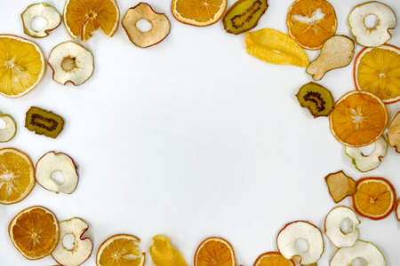 Organic apples, kiwis, oranges chips on white background with copy space for text. Healthy vegan...