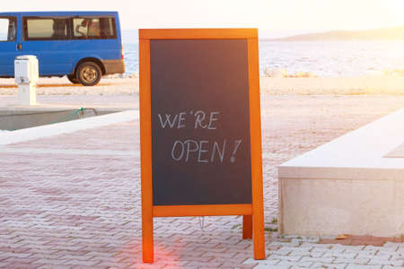 Chalkboard menu black color with an inscription - we are open. Mockup is standing near the...
