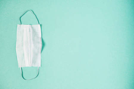White medical mask on blue background. Copy space for text. Face mask protection against pollution,...