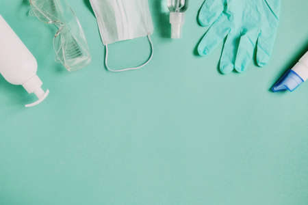 Coronavirus pandemic prevention. Top view medical surgical mask, hand sanitizer gel, glasses and gloves for hand hygiene corona virus protection. Copy space for text.の写真素材
