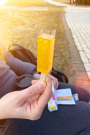 Marmalade on a stick in hand. Yellow jelly-candies, image picture.の写真素材