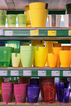 Pots for houseplants are sold at the store. Rows of different colored pots for indoor plants on shelves in a supermarket.の写真素材