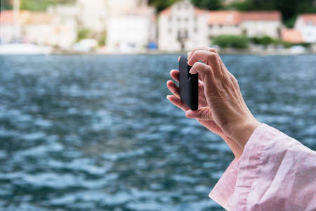 Woman hands holding mobile phone. Taking picture of nature by smartphone.の写真素材