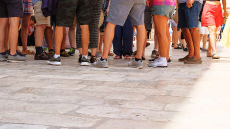 People walk along footpath. Yellow Paving slab. Pedestrian zone  in daylight, background. Urban walkway in sunny summer.の写真素材