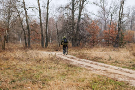 Riding on bike on sunny day among many trees. Sport and active healthy life concept. Cyclist in...