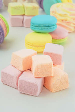 Various desserts: macaroons, marshmallows and zephyrs, closeup. Traditional colored sweet desserts for the holiday. Vertical view.の写真素材