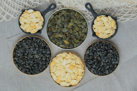 Pumpkin and sunflower seeds in bowl. Dried cereal seeds and fruits. Food ingredients.の写真素材