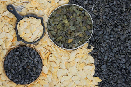 Pumpkin and sunflower seeds in bowl. Dried cereal seeds and fruits. Food ingredients, seed mix.