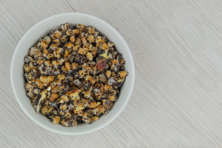 Ukrainian kutia with wheat, raisins, poppy seeds, walnuts, dried apples in bowl in wood background....