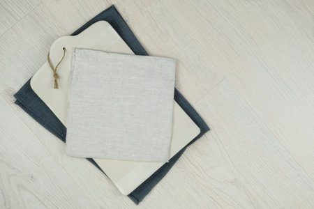 Ceramic kitchen board with a textile beige towel on wood background. Copy space.Top view.の写真素材