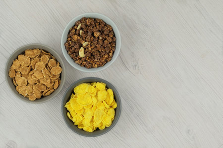 Breakfast cereals in bowls on a light wooden background. Fast food. Space for text. Top view.の写真素材