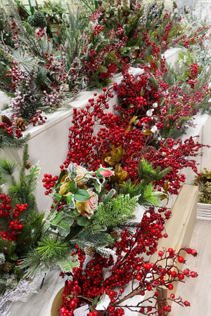 Christmas artificial berries for decoration prepared for sale in supermarket. Variety of colorful decoration on wooden shelves of large shop.の写真素材