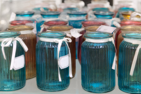 Colored glass vases are sold in shop. Jars for bouquets of flowers.