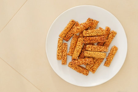Gozinaki in a ceramic plate on beige background. Sweet granola in beige plate for holiday. Homemade...