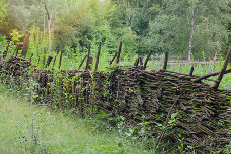 Traditional wooden farmhouse. Aged wooden fence in countryside. Village ethnographic museum. Vintage...