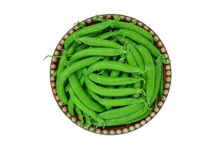 Green peas in a rural bowl isolated on white background. Fresh peas in bowl. Bowls of vegetables. Top view.の写真素材