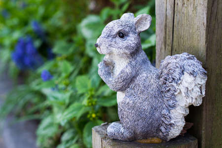 Squirrel garden decoration on wooden postの写真素材