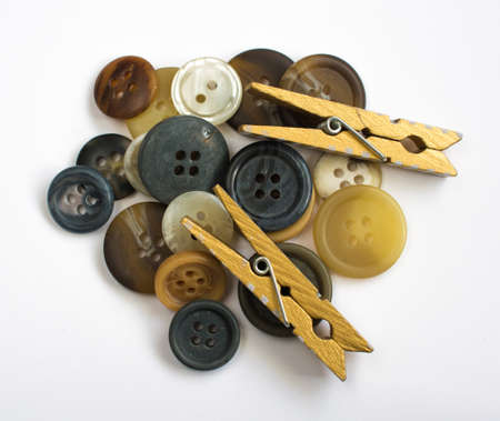 Pile of Assorted Colorful Buttons and Wooden Clothes Pins Isolated on Whiteの写真素材