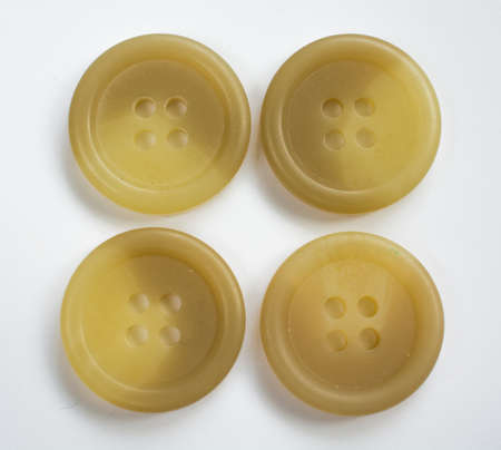 Four Cream Colored Plastic Buttons Isolated on White
