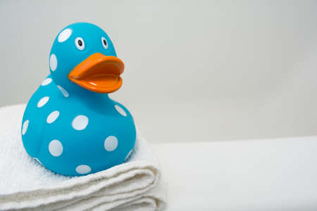 Cute Rubber Duck on a White Towel in a Bathroom Close Upの写真素材