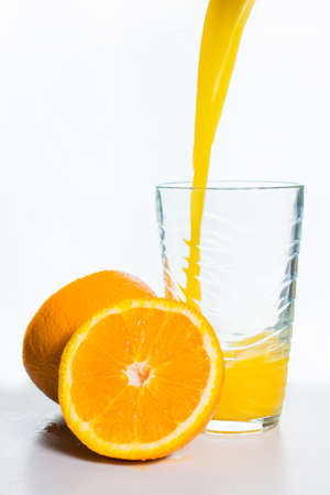 Glass of Orange Juice and Orange Slices Isolated on Whiteの写真素材