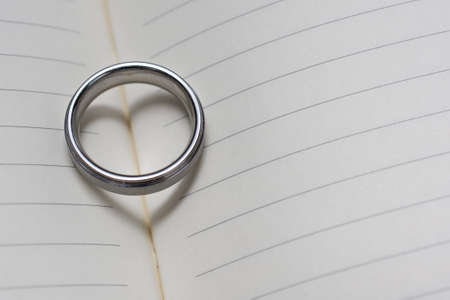 Wedding Ring Band on Book with Heart Shadow Close Up Angled Viewの写真素材