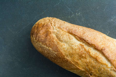 Full bread baguette on black surface top viewの写真素材