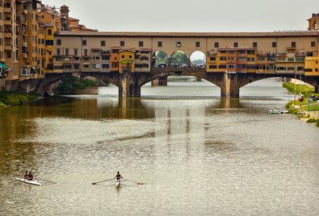 Rowing, Sculling, Shells Boats on Arno River Ponte Vecchio Covered Bridge Reflection Florence Italy Bridge is the oldest bridge in Florence built in 1345 by Neri di Fioravanteの写真素材