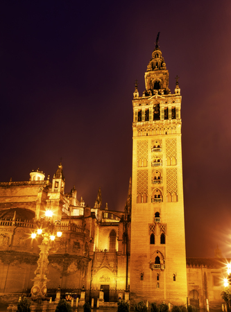 Giralda Spire, Bell Tower, Seville Cathedral, Rainy Night, Seville, Andalusia Spain   Built in the 1500s   Largest Gothic Cathedral in the World and Third Largest Church in the World   Burial Place of Christopher Columbus   Giralda is a former minaret conの写真素材