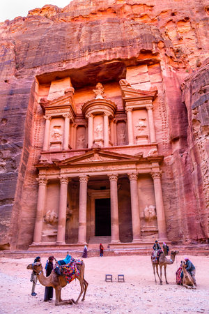 Yellow Treasury in Morning Becomes Rose Red in Afternoon Camels Siq Petra Jordan Petra Jordan.  Treasury built by the Nabataens in 100 BC. Canyon becomes rose red when sun goes.  Inside buildings walls create many abstracts close up.  The rose red can becのeditorial素材