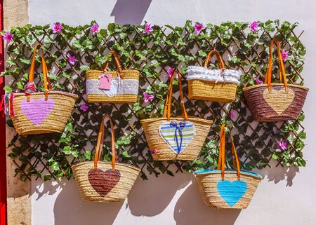 Straw Baskets Bags Colorful Handicrafts 11th Century Medieval Town Obidos Portugal.  Rooster is the symbol of Portugalの写真素材