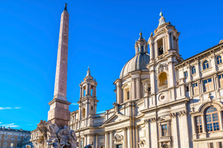 Saint Agnese In Agone Church Obelisk Piazza Navona Egyptian Obelisk Rome Italy.  Piazza site of Roman racetrack created in 1600s.  Obelisk part of Fontana dei Quattro Fiumi, Bernini fountain created 1651.  Saint Agnese Church created in 304 AD later rebuiのeditorial素材