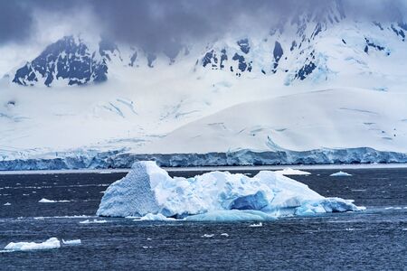 Iceberg Snow Mountains Blue Glaciers Dorian Bay Antarctic Peninsula Antarctica.  Glacier ice blue...