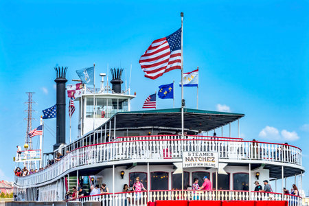 Tourists Natchez Steamboat Riverboat Flags Wharf Mississippi River New Orleans Louisiana.  One of the last Sternwheel Steamboats on the River and in the United Statesのeditorial素材