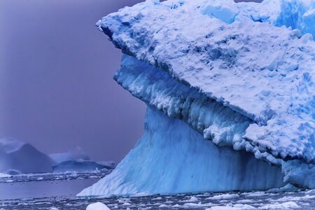 Snowing Floating Blue Iceberg Reflection Paradise Bay Skintorp Cove Antarctica. Glacier ice blue...