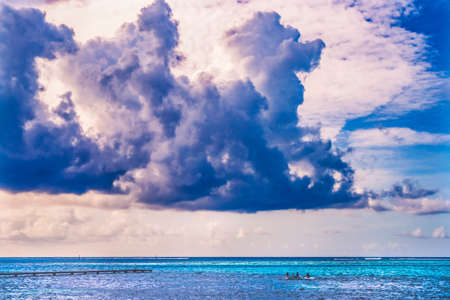 Colorful Large White Cloud Canoes Pier Blue Water Reef Moorea Tahiti French Polynesia. Different blue colors from lagoon and coral reefs and outer reef waves and deep blue Pacificの写真素材