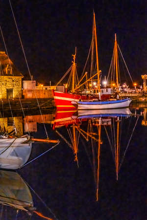 Colorful Night Red Fishing Boat Trawler Marina Sailboats Waterfront Reflections Stores Restaurants Inner Harbor Honfluer France.  Honfluer is famous for its reflections, which inspired Monetの写真素材