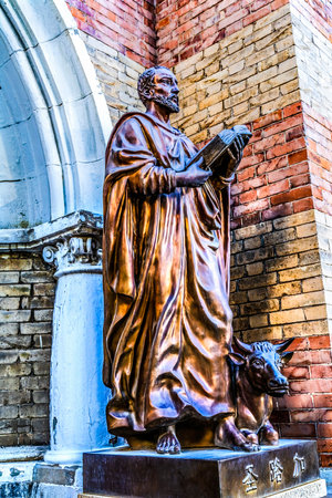 Colorful St Luke Statue Gospel Writer Oxen Facade St Joseph Cathedral Xikai Church Tianjin China. Roman Catholic church built 1916.の写真素材