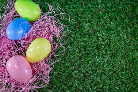 Easter eggs on a basket with grass and green background for happy easter celebration