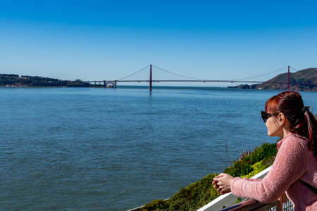 Female adult while enjoying the skyline view of San Francisco USA and Golden Gate Bridge from...