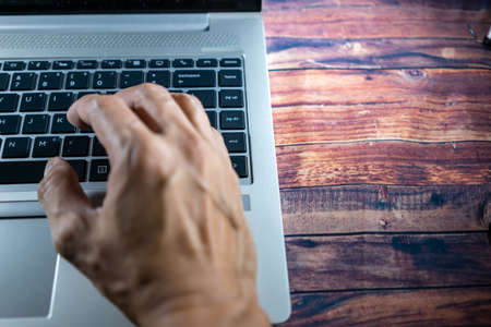 Laptop with a hand while typing or encoding. Business concept, office concept, work from home...
