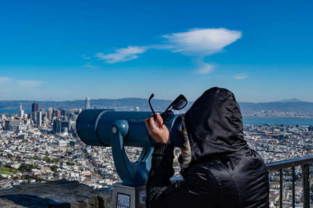 A tourist while looking at the Point of view telescope at Viewpoint Twin Peaks San Francisco, California USA, March 30, 2020のeditorial素材
