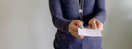 Businesswoman showing a blank greeting card. Office professional woman while holding a blank white...